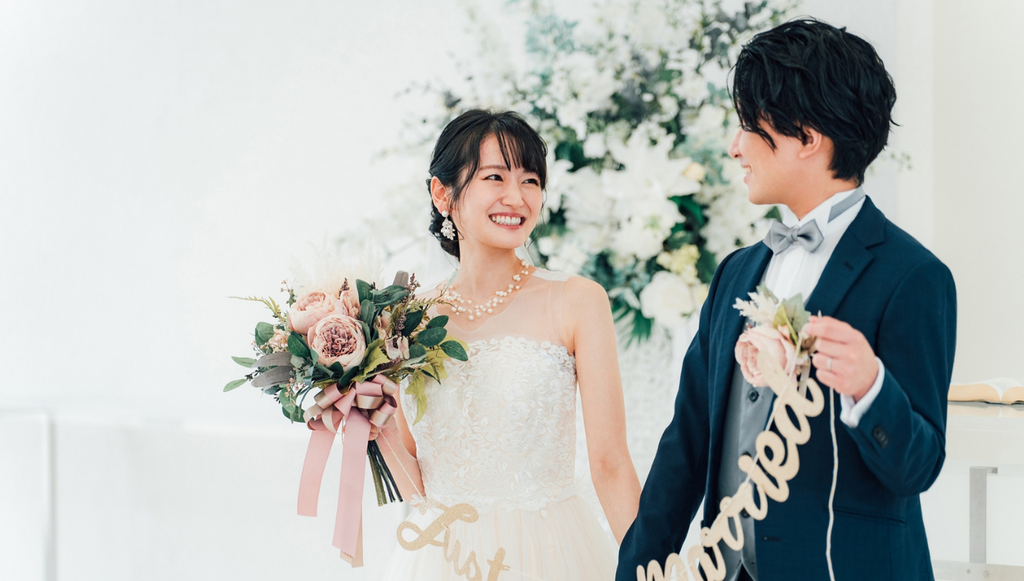 結婚式場でガーランドを持つ新郎新婦